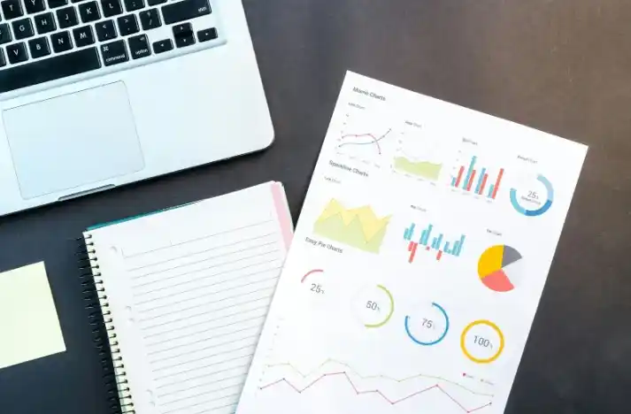 Laptop y gráficos mostrando análisis de datos, ilustrando los beneficios del SEO en marketing digital