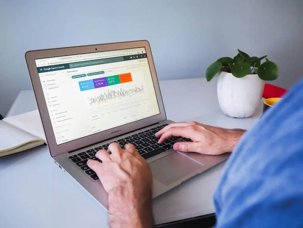 Persona utilizando Google Search Console en una laptop para analizar el rendimiento de SEO, una práctica común en agencias SEO.