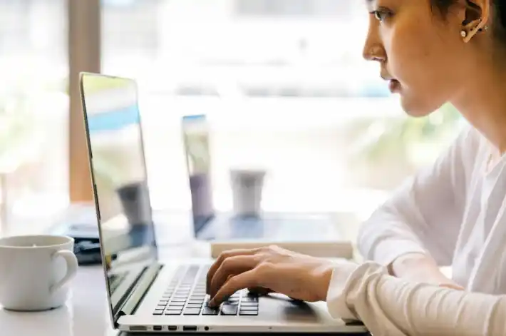 Persona trabajando en una laptop para redactar y analizar los mejores títulos SEO