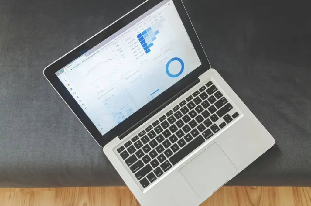 Laptop mostrando gráficos y estadísticas de rendimiento web, representando el análisis de diferentes tipos de SEO.