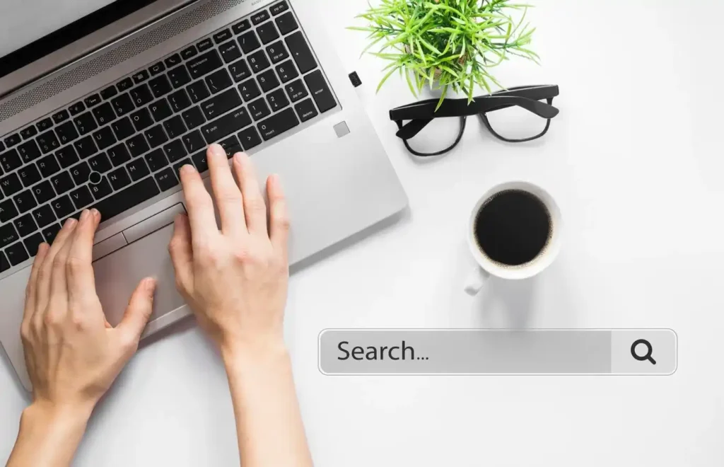 Vista superior de un espacio de trabajo con un portátil, una taza de café, una planta y gafas