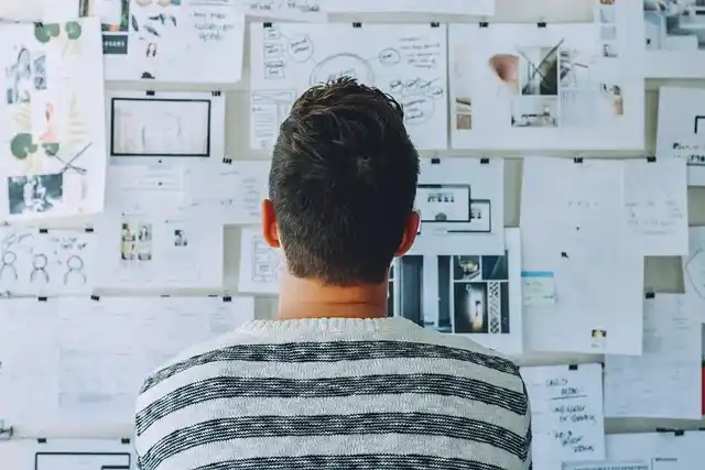 Persona analizando ideas en pizarra para definir cómo hacer un plan de marketing de contenidos eficaz