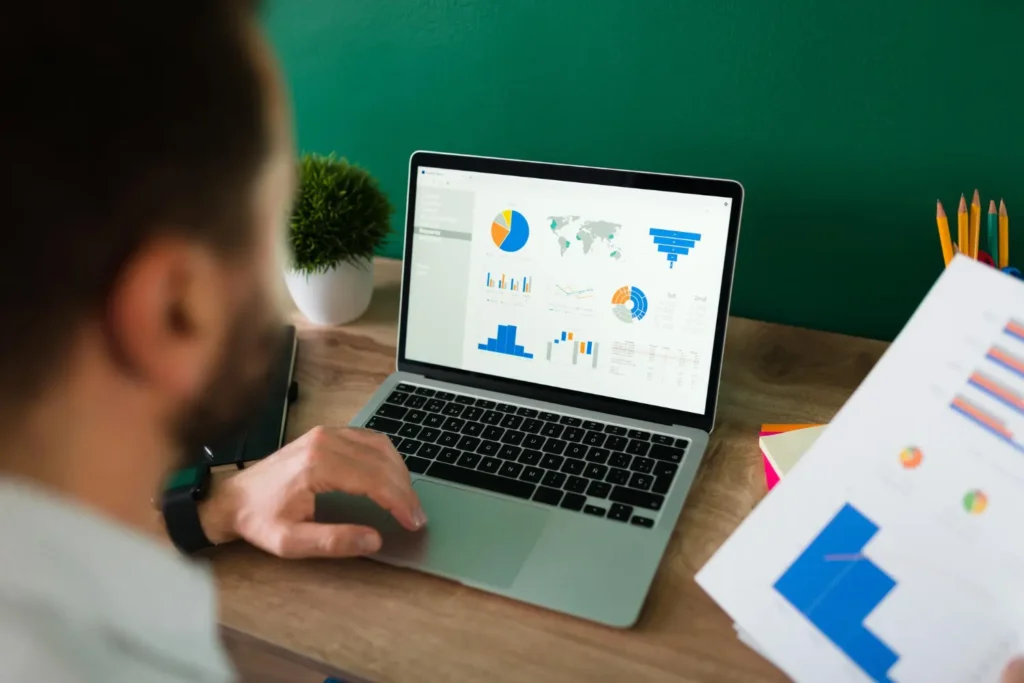 Persona revisando métricas SEO en laptop con gráficos y reportes para analizar tráfico y rendimiento del sitio web